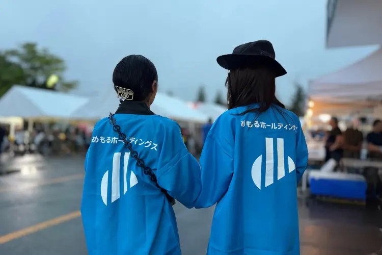 むらもと祭りを楽しむ女性社員2名の後ろ姿