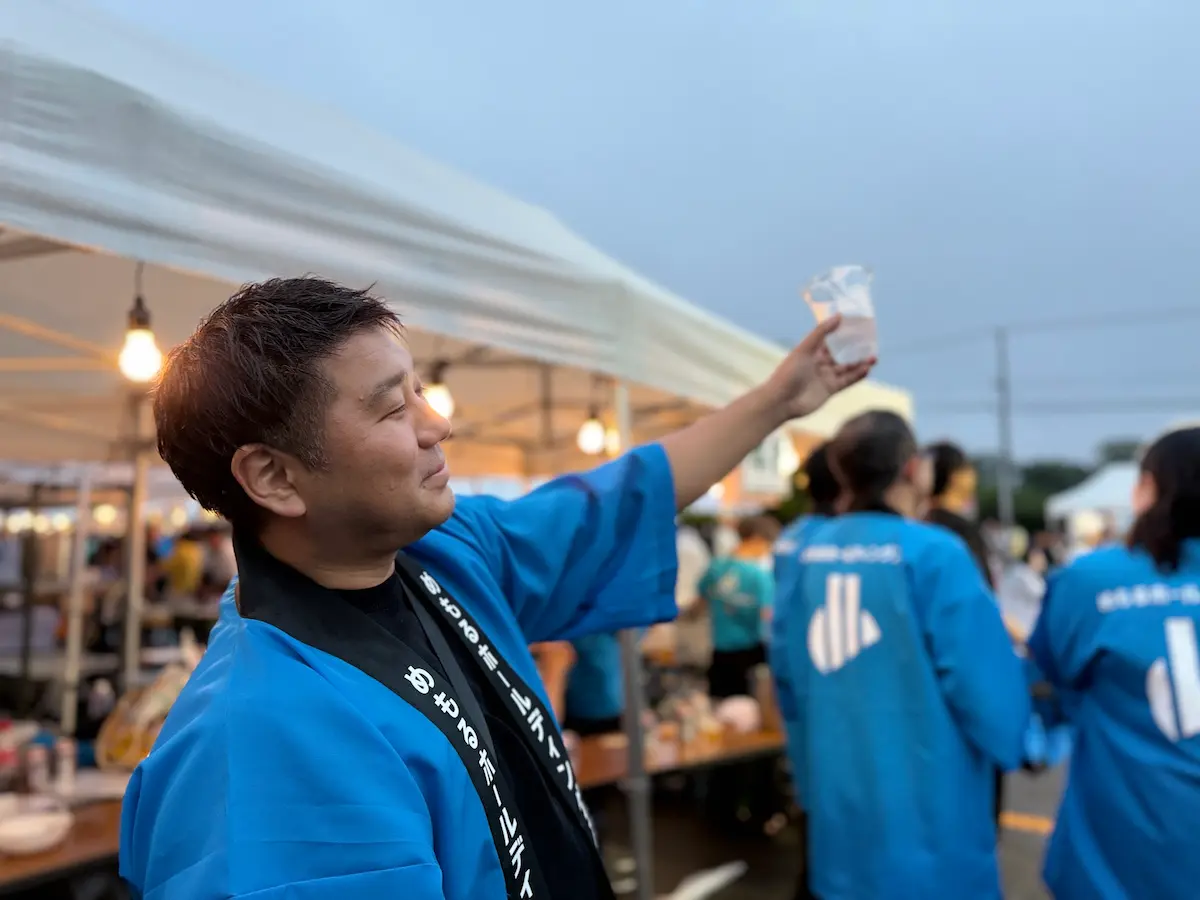 ビールを高く掲げるいとあ竹本社長